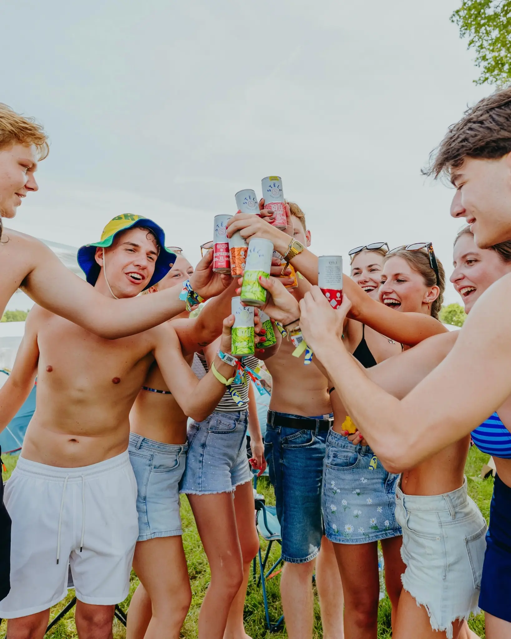 A group of friends raising their drinks together in the sun at Sunrise Festival